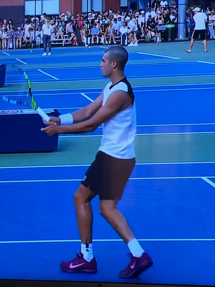 Tennis player preparing to serve.