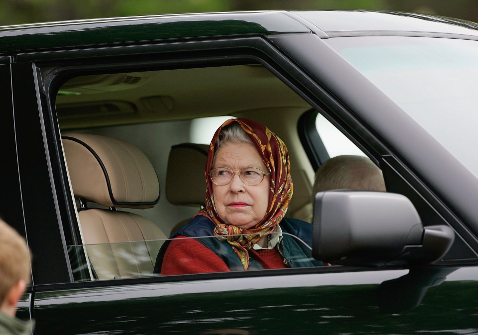 Queen Elizabeth II driving a Range Rover.