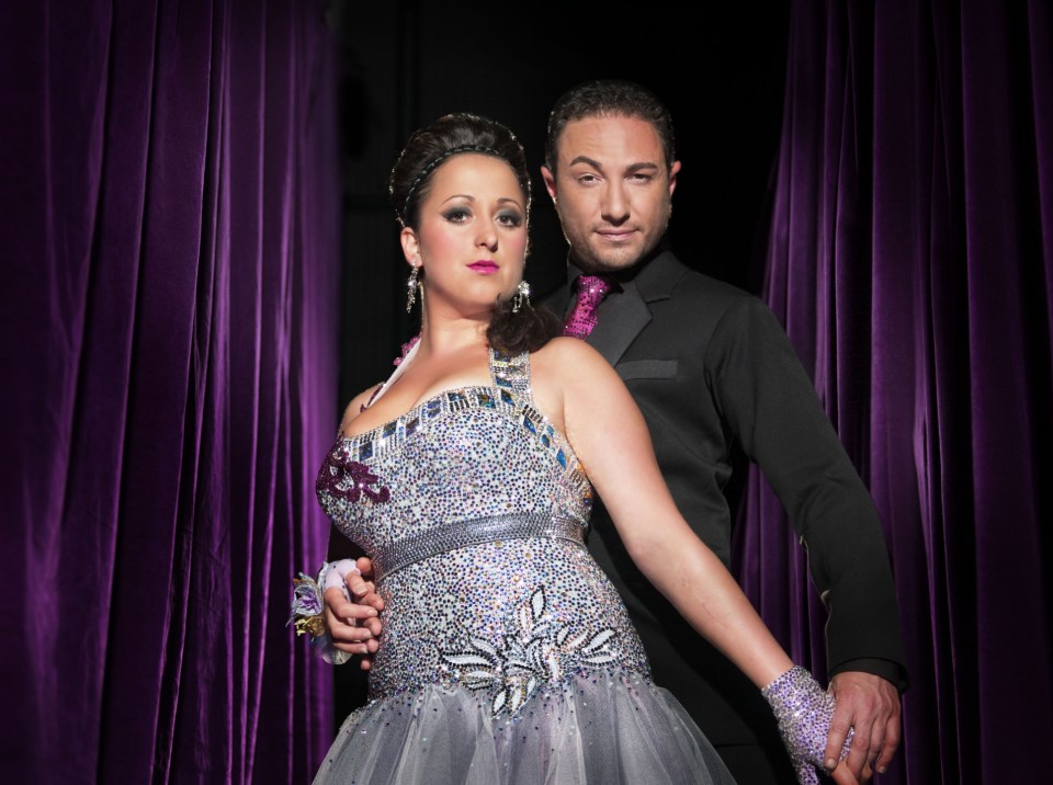 Natalie Cassidy and Vincent Simone holding hands.