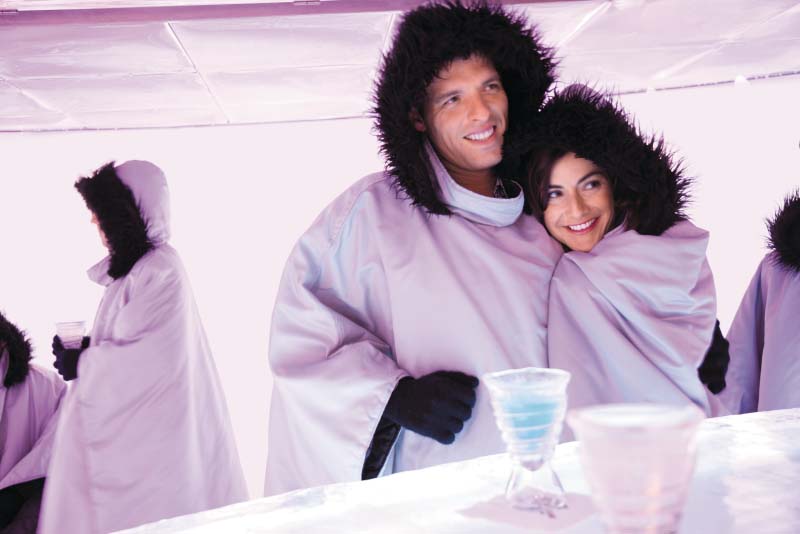 Couple in warm clothing at an ice bar.