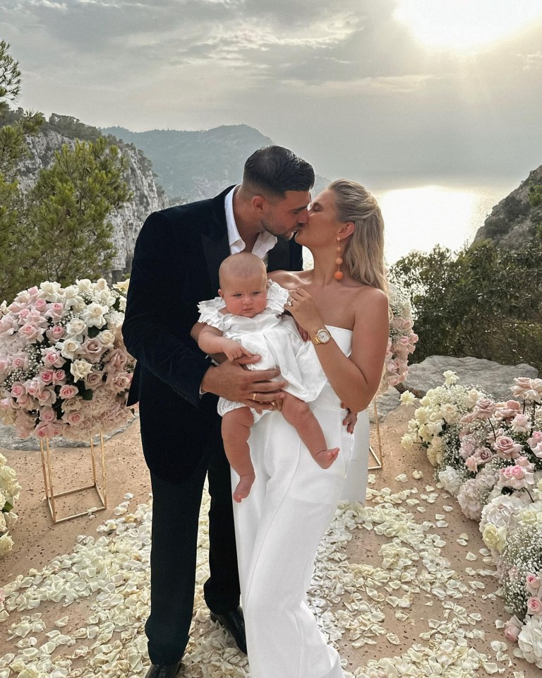 Molly-Mae Hague and Tommy Fury kissing with their baby.