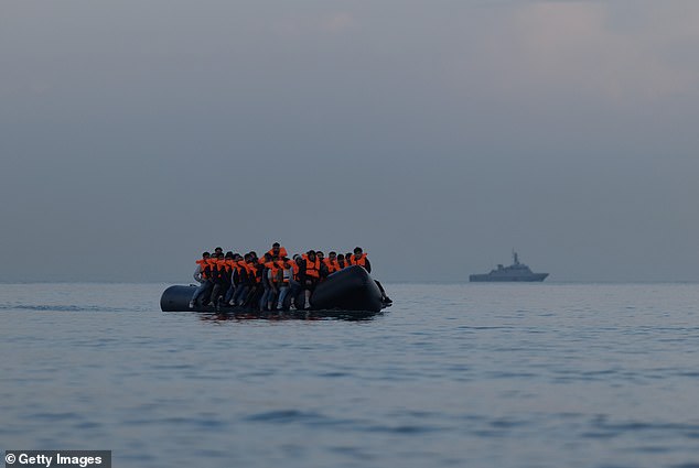 A group of people, believed to be migrants, are pictured on a small boat near Gravelines, northern France