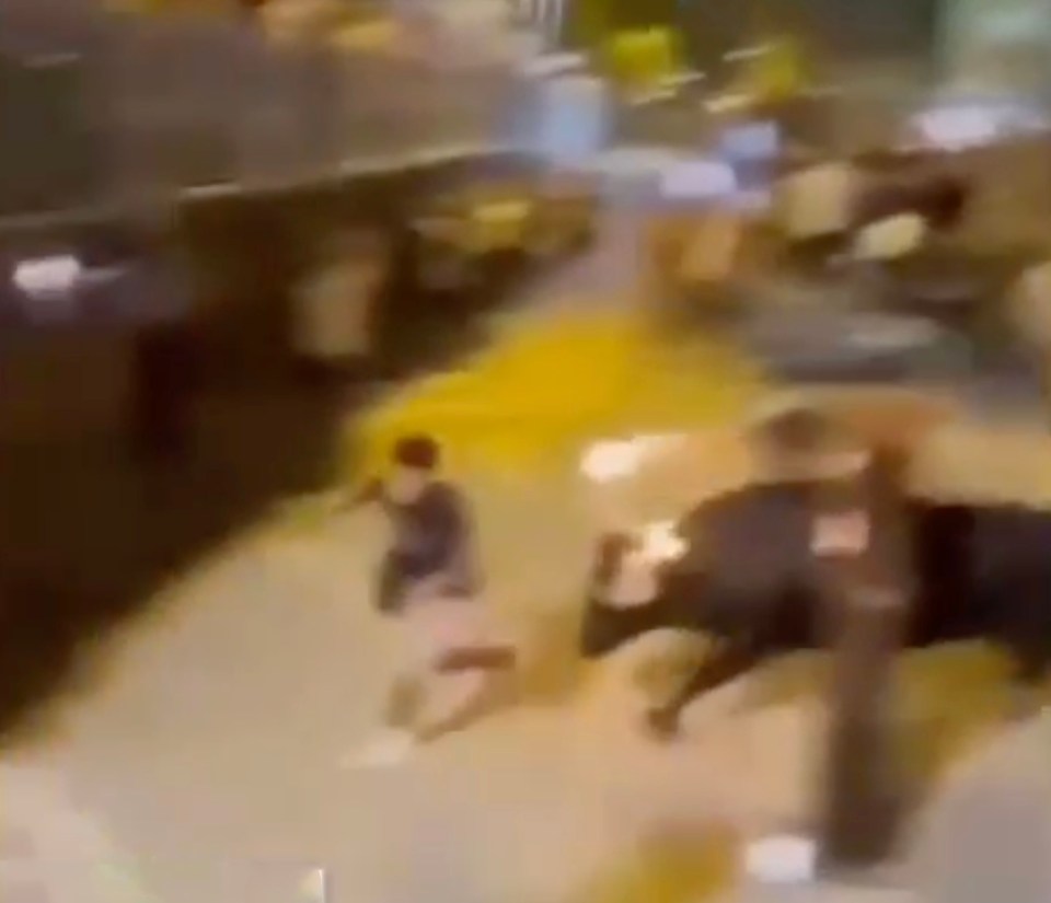 A bull with flaming torches on its horns knocks a man to the ground and takes his bag.