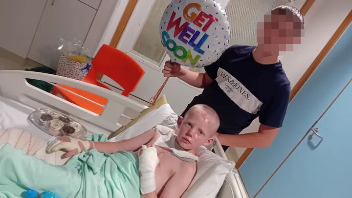 A boy in a hospital bed with bandages, holding a "Get Well Soon" balloon.