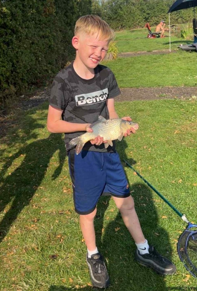 Boy holding a fish he caught.