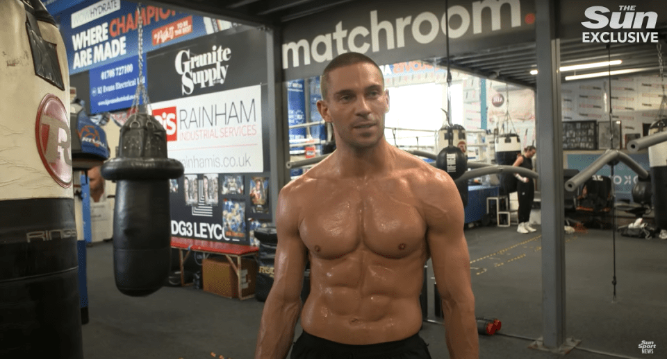 Shirtless man in boxing gym.