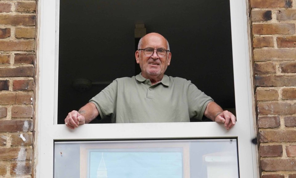 Man leaning out of window, smiling.