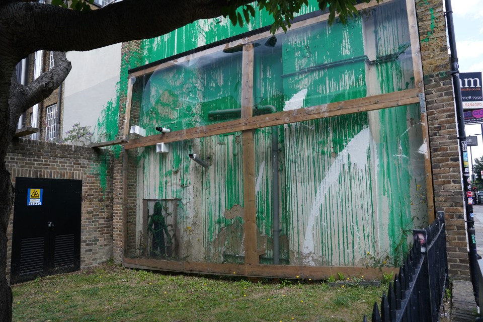 Banksy artwork protected by a wooden frame.