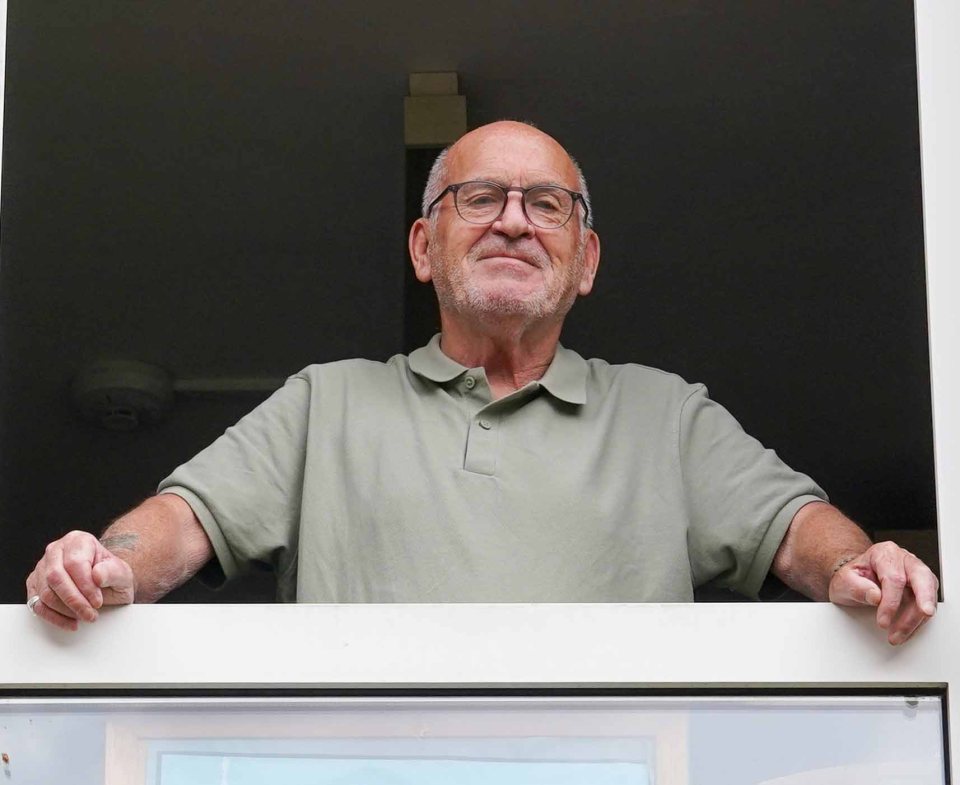 A man leaning on a windowsill.
