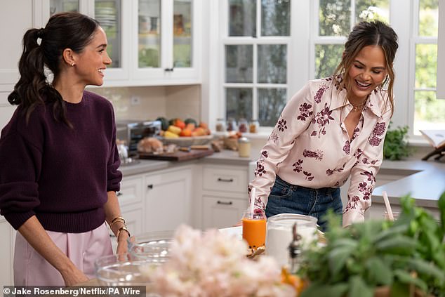 Meghan with model Chrissy Teigan, who looks like someone attacked her face with a bicycle pump