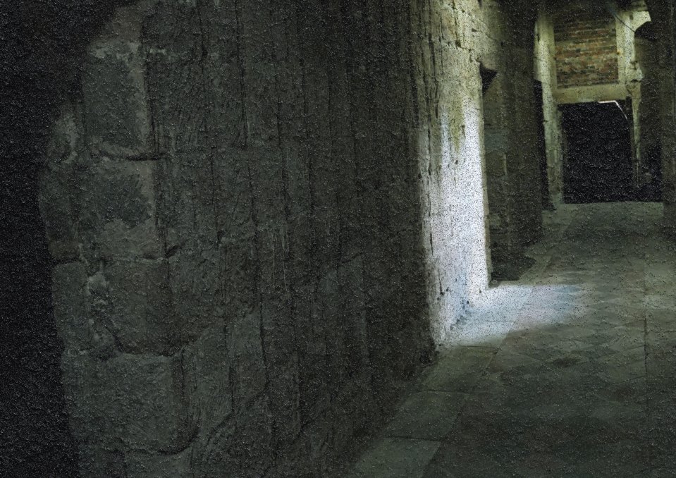 Dark, stone corridor with a light at the end.
