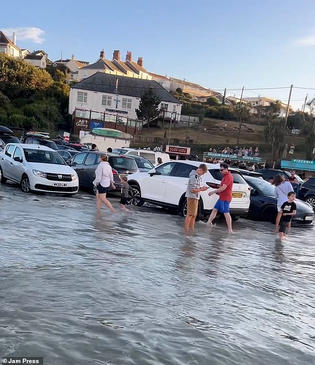 In hilarious footage captured on video, beachgoers visiting Polzeath, Cornwall on 25 August were left in stitches after being forced to wade into the water to claim their cars