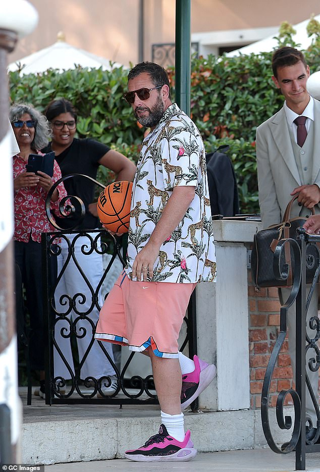 He paired the shirt with a pair of pale pink Nike shorts and black and bright pink trainers as he was seen carrying a basketball