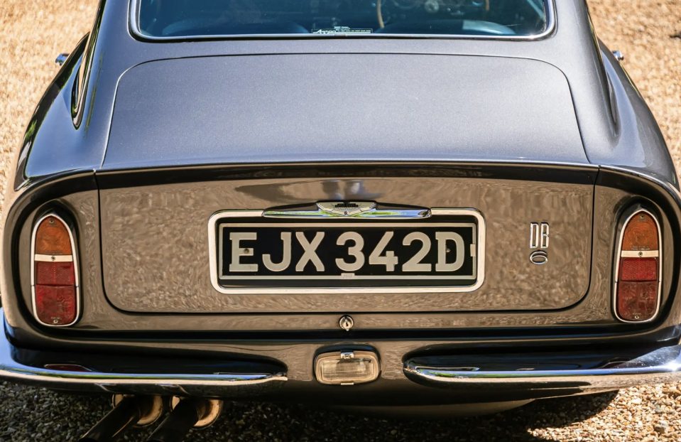 Rear view of a grey Aston Martin DB6 Mk1 Vantage with license plate EJX 342D.