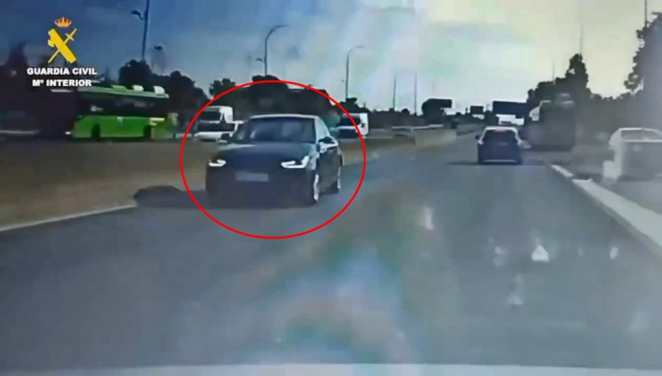 Video still of a car driving the wrong way on a motorway.