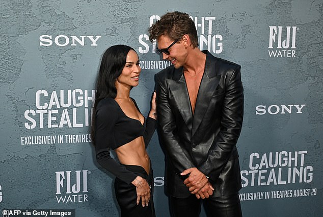 Zoe flashed an amused smile as she touched Austin's upper arm