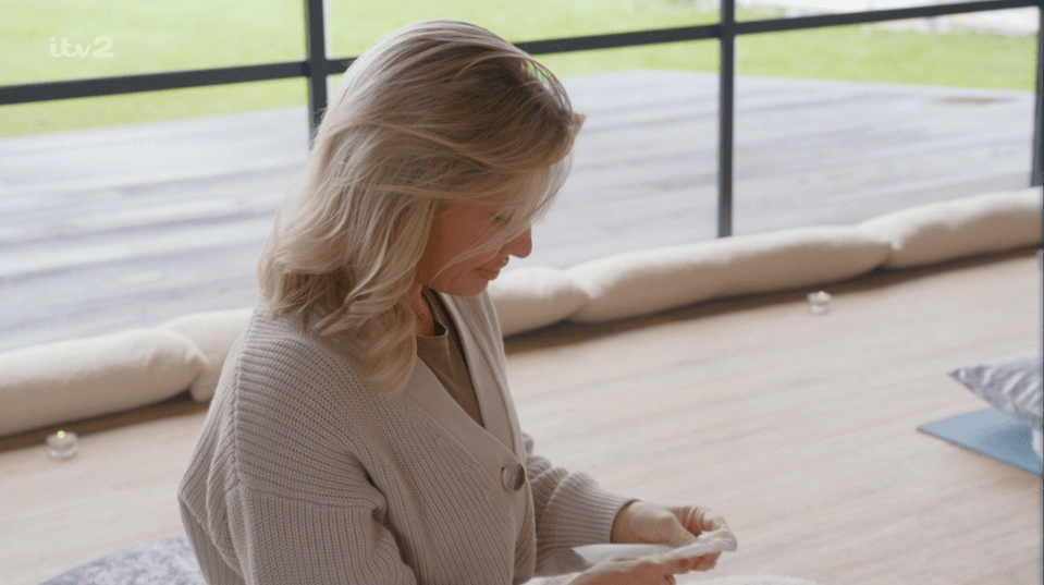 Woman examining something small in her hands.