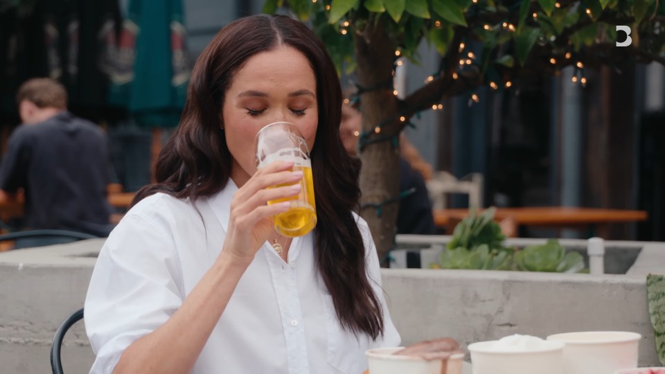 Meghan Markle drinking beer outdoors.
