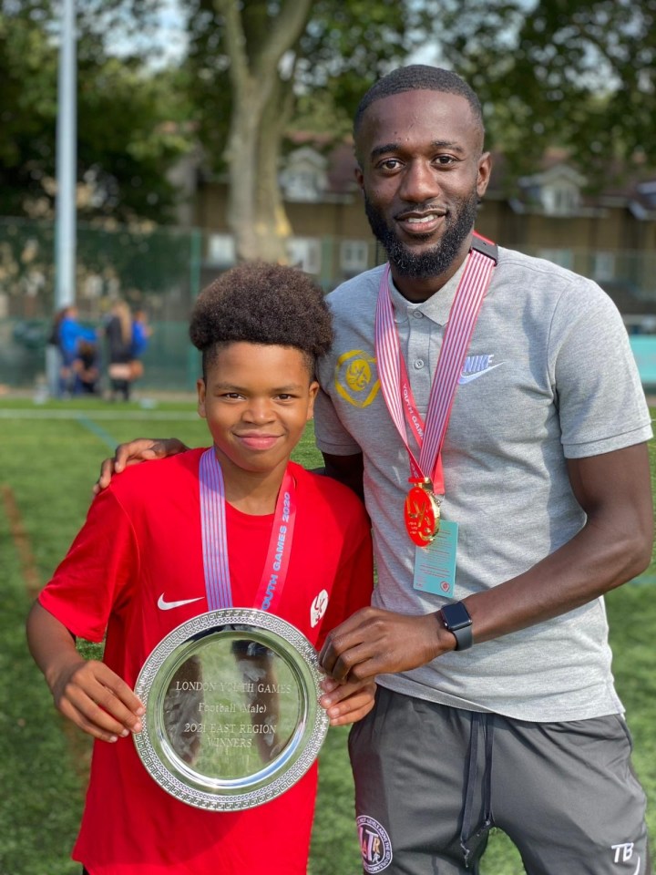 Young boy and man holding a London Youth Games trophy.