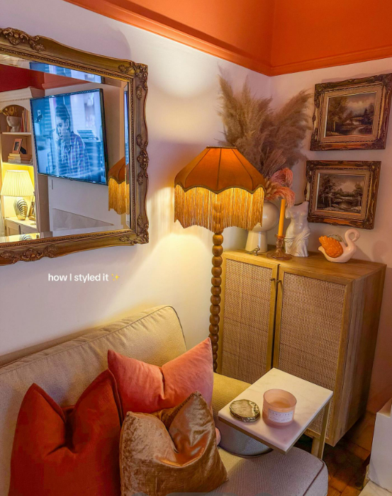 Living room corner with sofa, floor lamp, and decorative items.
