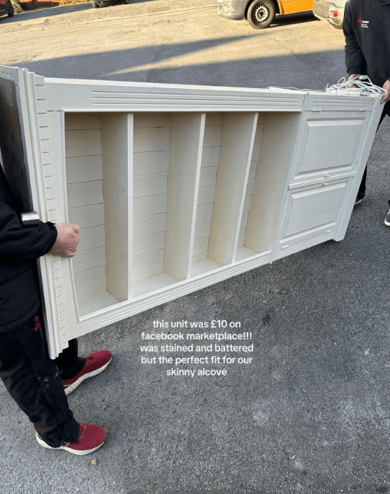Person carrying a white wooden shelving unit.