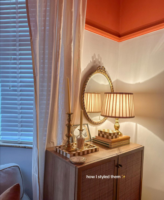 Styled side table with lamp, candles, and books.