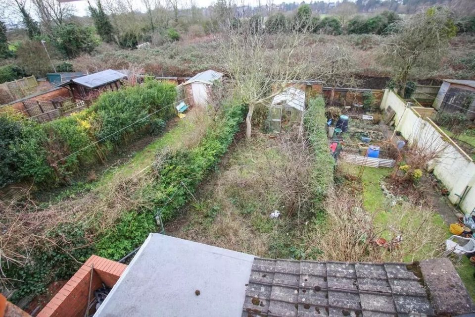 Aerial view of a garden with sheds and a greenhouse.