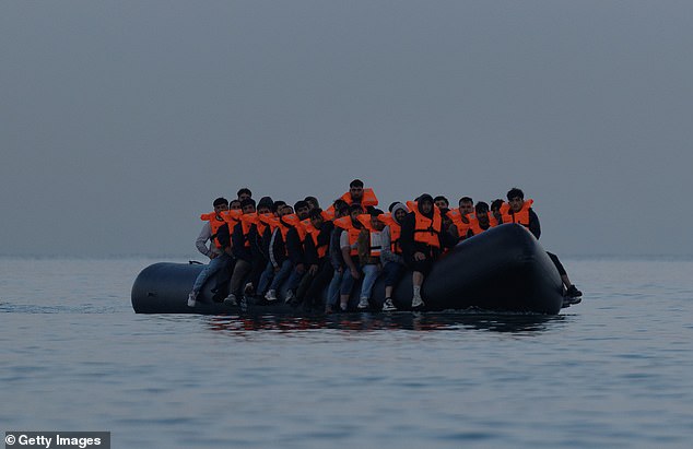 A group of people, believed to be migrants, are pictured on a small boat near Gravelines, northern France