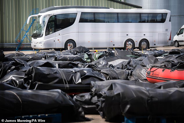 A horizontal view of small boats and engines used by people thought to be migrants to cross the channel at a warehouse facility in Dover