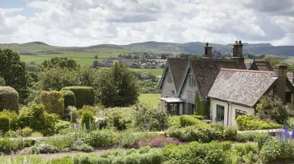 Cragside Garden Cottage in a garden overlooking a valley and village.