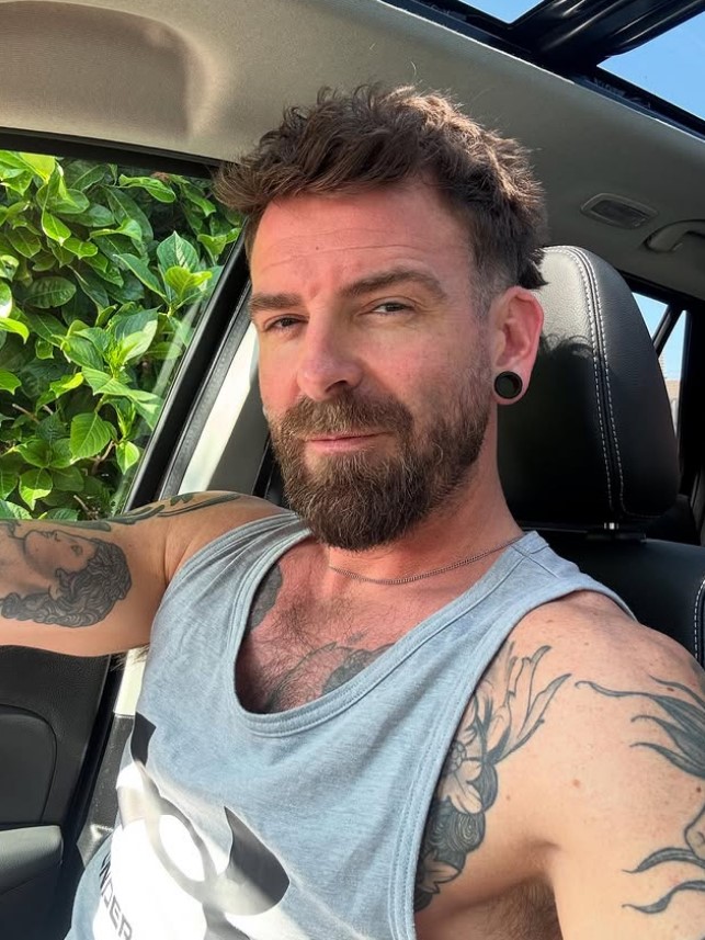 Selfie of a man with tattoos in a car.