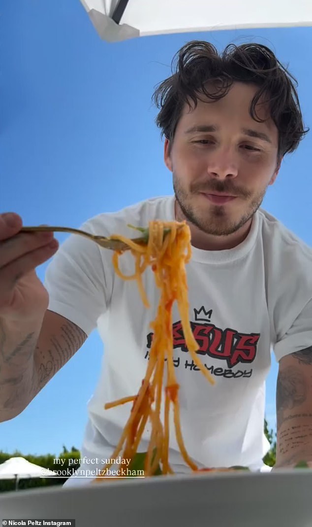 He was then seen presenting his dish to his wife Nicola Peltz, who shared a clip of her husband joining her poolside and saying: 'Darling, do you wanna try some? It is so good with this basil', before the duo said 'I love you' to one another