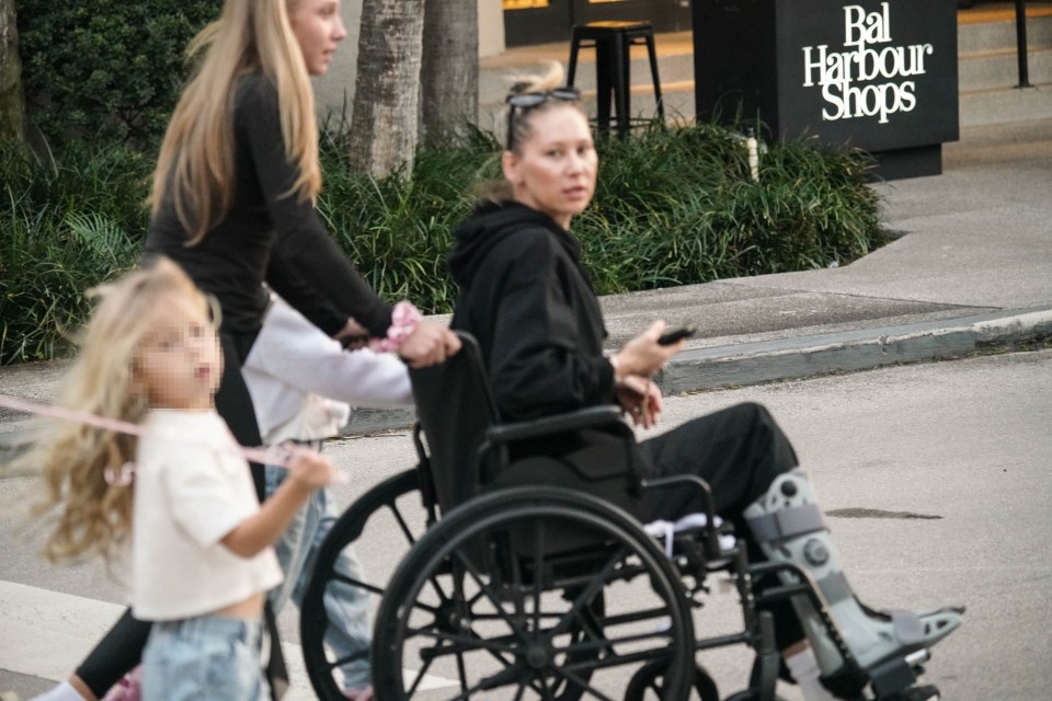 Anna Kournikova in a wheelchair with an orthopedic boot, during a family shopping trip.
