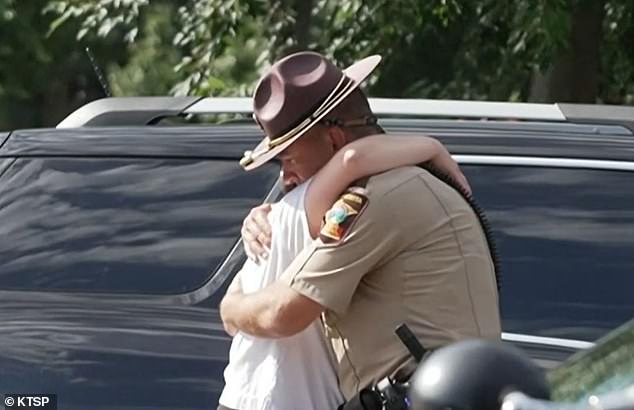A state trooper embraced someone in a hug at the scene of the shooting Wednesday morning