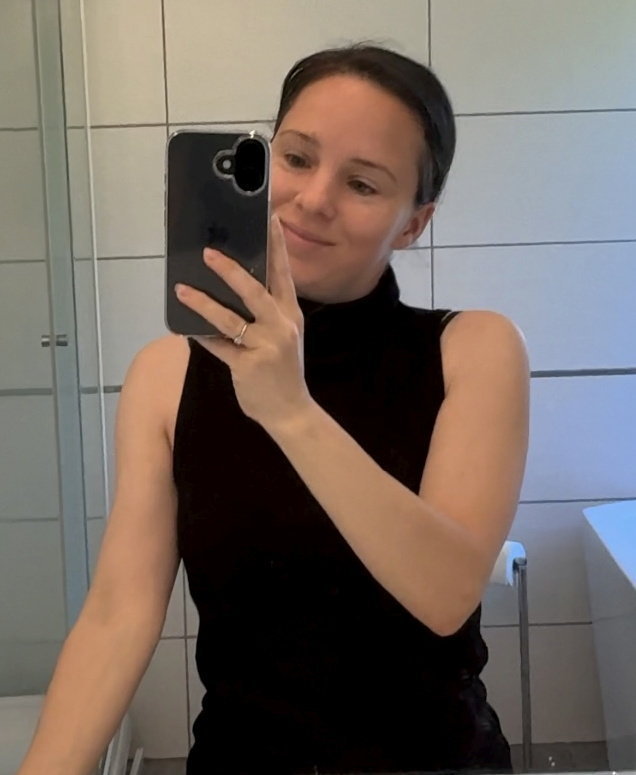 Woman taking a selfie in a bathroom.