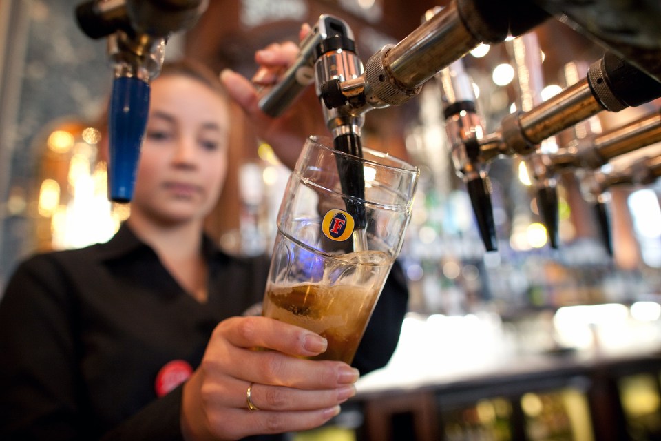 Bartender pouring Fosters Lager.