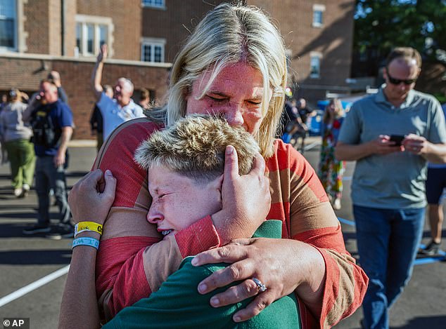 A parent hugs her son during an active shooter situation at the Annunciation Church