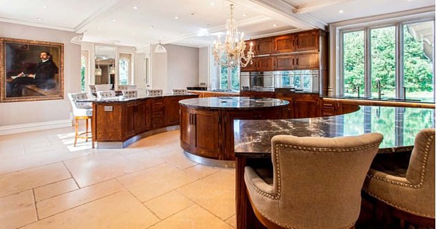 Downstairs houses an extensive wine cellar as well as a large modern kitchen with a circular island and curved units