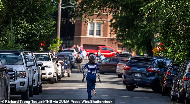 Within hours of the shooting, FBI director Kash Patel announced they were investigating the killings as an 'act of domestic terrorism' and anti-Catholic hate crime. (Pictured: A parent runs towards the Annunciation Church)