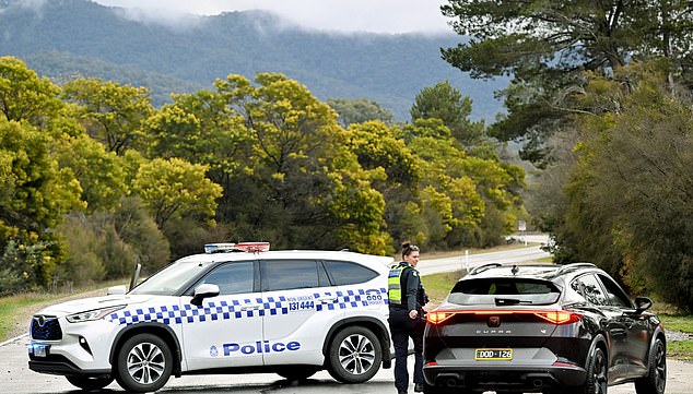 Police divert traffic at a road block to a property as the search intensifies for a fugitive linked to the murder of two police officers in Porepunkah on August 27, 2025. Police searched the Australian bush on August 27, for a heavily armed 56-year-old gunman still on the run a day after allegedly killing two officers and wounding a third. (Photo by William WEST / AFP) (Photo by WILLIAM WEST/AFP via Getty Images)
