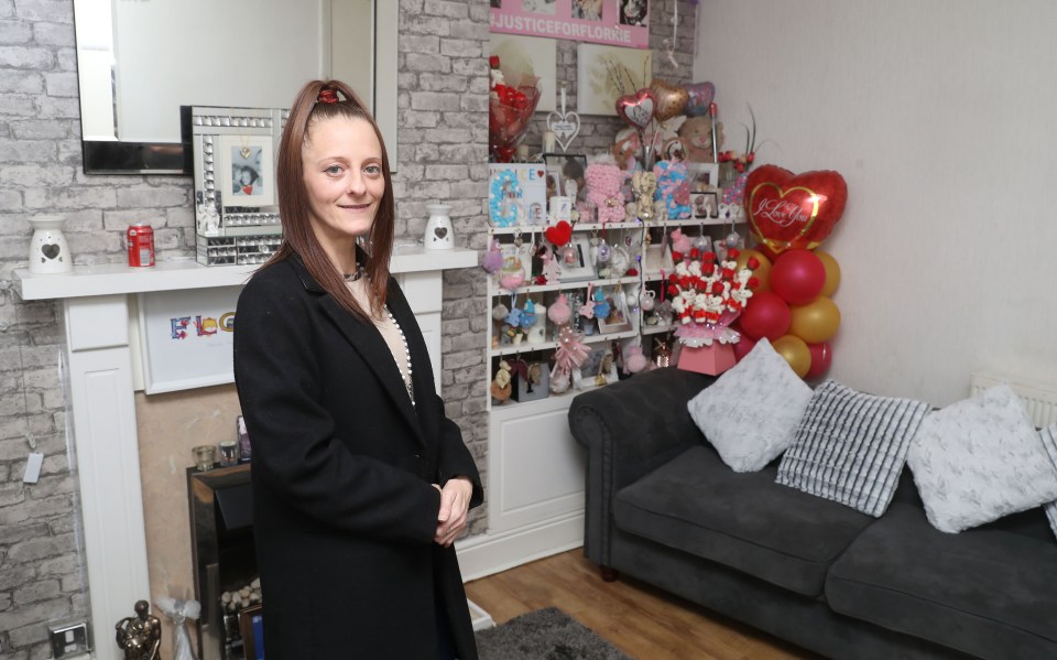 A woman stands in her living room.