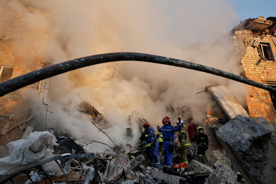Rescuers amidst smoke and rubble at a bombed building in Kyiv.