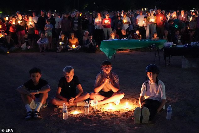 Robin Westman, 23, wrote an ode to death titled 'But Not The End' outlining fears of dying with 'regrets that my name not be known for something more', according to the Star Tribune. (Pictured: Children mourning at a vigil on Wednesday night)