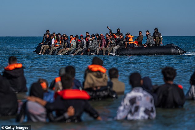 Migrants try to board a dinghy to cross the English Channel in Gravelines, France, on Monday