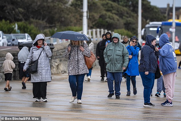 Umbrellas come out on the promenade at Weston-super-Mare in Somerset yesterday