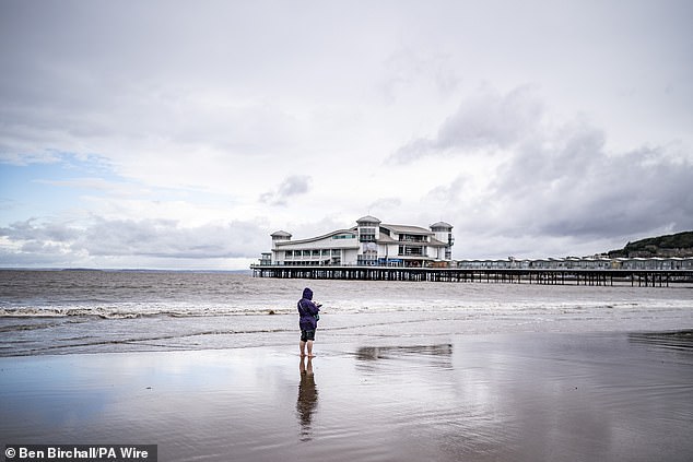 People on the beach at Weston-super-Mare in Somerset during wet weather yesterday
