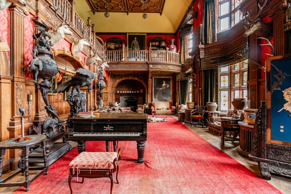 Interior of Kinloch Castle on the Isle of Rum, featuring a grand piano and ornate furnishings.