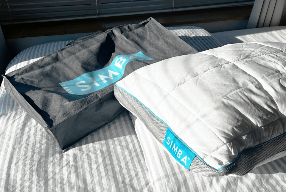Simba pillow and storage bag on a bed.