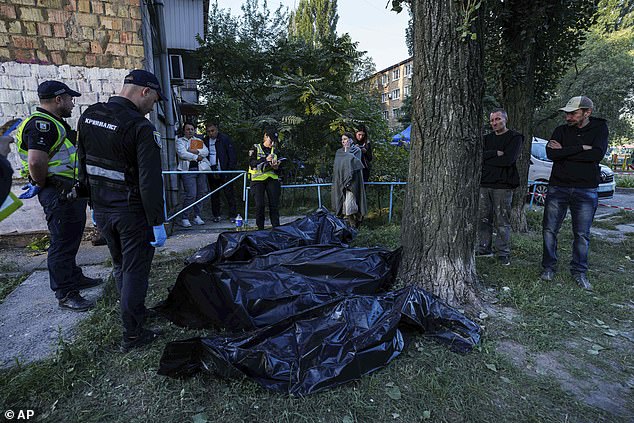 Human remains on the ground are placed in body bags. It has been reported that at least 14 people have died, including a 14-year-old girl