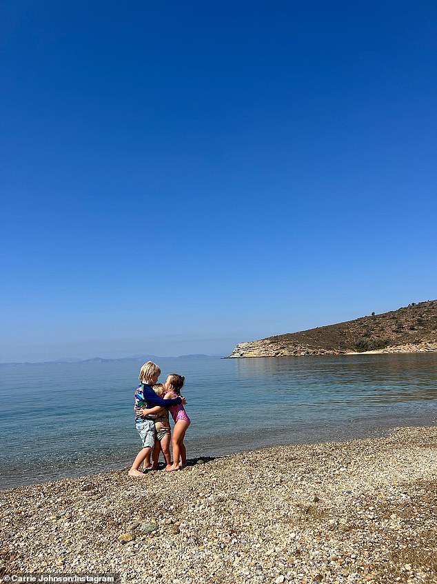 Wilfred, Romy and Frank have a cuddle on the beach during the family holiday to Greece